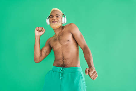 Multiracial man moving to the rhythm of music while using headphonesの写真素材