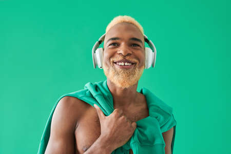 Multiracial bearded man listening music at headphones and smiling toothyの写真素材