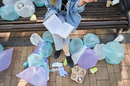 Woman feeling that everything is all right while sitting at the bench inside the rubbish
