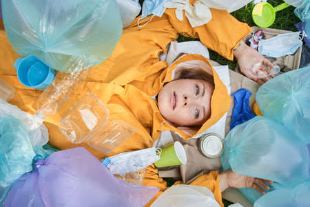 Woman suffering of hoarding abnormal disorder at her planet and laying around the rubbishの写真素材