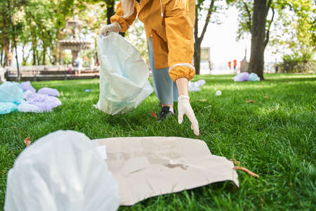 Active environmentalist wearing protective gloves cleaning the parkの写真素材