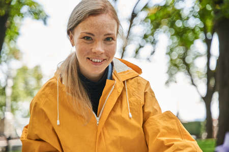 Female volunteer smiling to the camera while cleaning park of the rubbishの写真素材