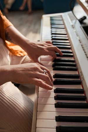 Caucasian woman sitting at the piano playing her own songの写真素材