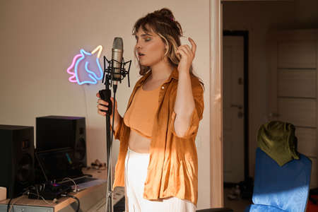 Female vocal artist singing singing her own song at the microphoneの写真素材