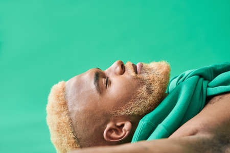 Peaceful multiracial guy laying at the floor with closed eyesの写真素材