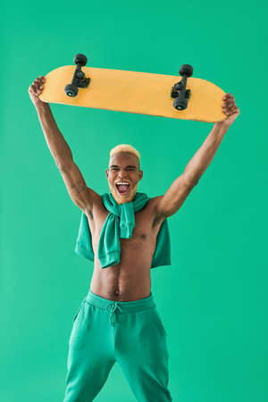 Young man holding skate on outstretched arms and showing crazy and amazed emotionsの写真素材