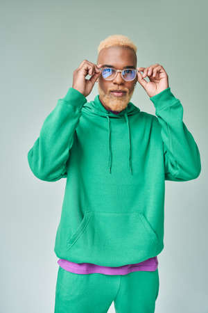 Multiracial man wearing glasses standing with hands near face and looking to the cameraの写真素材