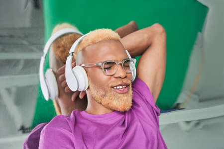 Multiracial man with headphones at his head enjoying of the musicの写真素材