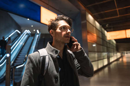 Man in the hall station with escalator at the backgroundの写真素材