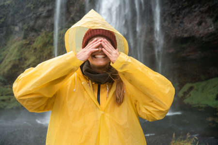 Woman closed her eyes and smiling toothy while spending time at the amazing places