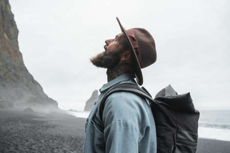 Male tourist in brown hat looking at the Iceland views and feeling breathtaking emotionsの写真素材