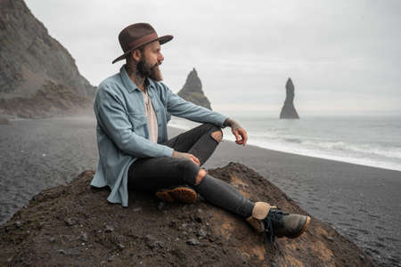 Guy enjoying of his vacations while looking at the ocean and being deep in thoughts