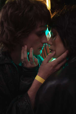 Man and woman touching faces of each other while having romantic date at the evening