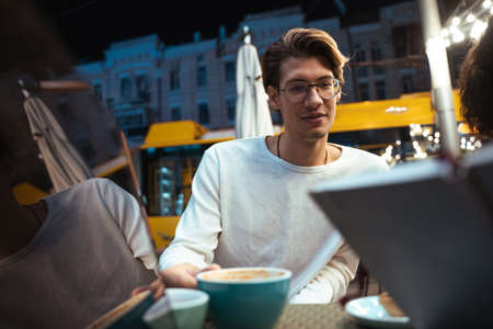 Man working with business partners at the laptop while sitting at the street cafeの写真素材