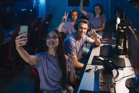 Woman shooting at her smartphone at the E sport competition with another gamersの写真素材