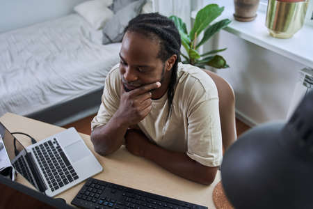 Man attentively looking at the laptop screen while having video call and brainstorming