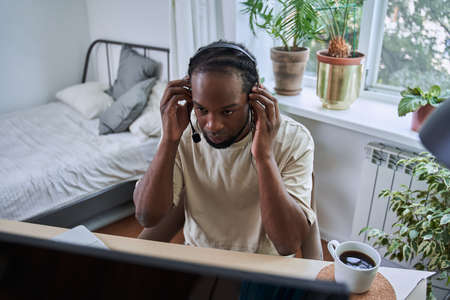 Multiracial support manager in headset working with his computerの写真素材
