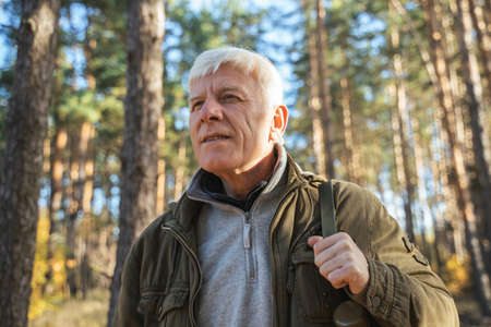 Senior male traveler with backpack in calm natureの写真素材
