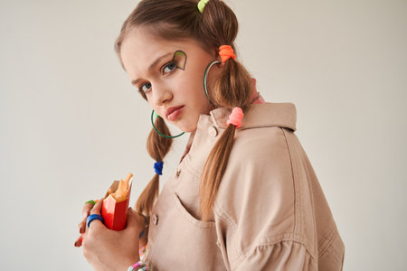 Fashion portrait of the cute teenage girl in creative look posing to the cameraの写真素材