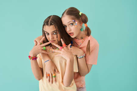 Teen friends embracing with each other while posing at the studio