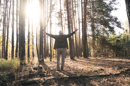 Overjoyed old man feeling freedom while traveling in forest during the autumnの写真素材