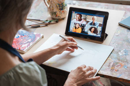 Female teacher drawing while holding online lesson for her studentsの写真素材