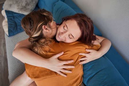 Loving  couple embracing each other while sitting at the sofa at the weekendの写真素材