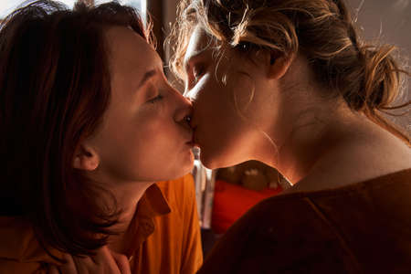 Happy positive  couple kissing each other while enjoying cozy romantic morningの写真素材