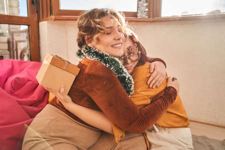 Women wearing party accessorizes embracing with each otherの写真素材