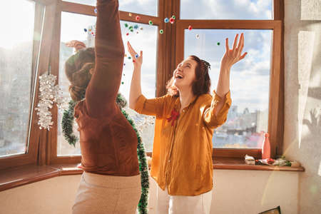 Overjoyed  girls throwing up confetti and having fun during the partyの写真素材