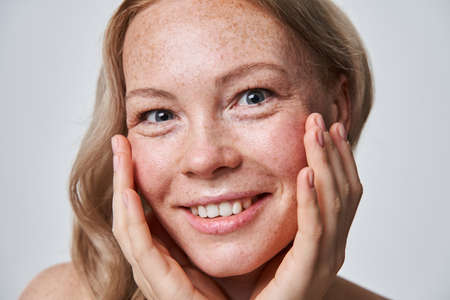 Caucasian freckled woman with naked shoulders and nude makeupの写真素材