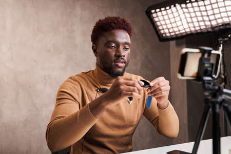 Guy speaking in front of smartphone camera for his blog channelの写真素材