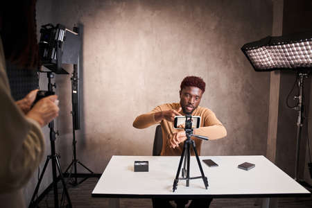 Smart multiracial blogger man filming new blog video with professional camera