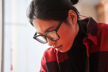 Concentrated man wearing glasses looking at the paper while drawing traditional bannerの写真素材