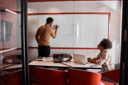 Attractive young colleagues are working together in office
