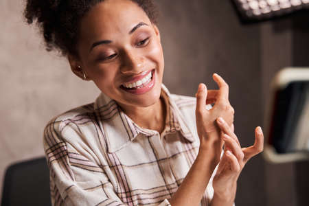 Blogger woman showing her hand with tone cream while broadcasting make up tutorial