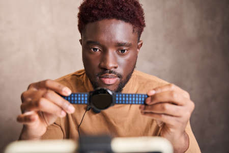 Man showing watches to the camera while making video about different devices
