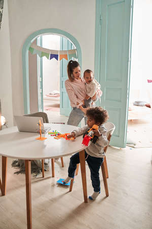 Mother enjoying great time with her lovely baby, holding him at her hands and bondingの写真素材