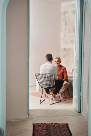 Father and son talking together at the living room during the weekendの写真素材