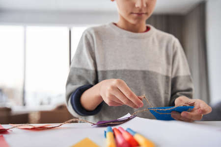 Caucasian male child standing at the table and preparing festive decor for the Fathers dayの写真素材
