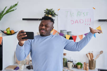 Multiracial man making selfie at the smartphone with placard for Fathers Dayの写真素材