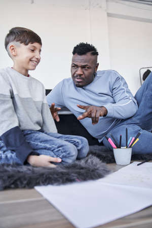 Cute pensive caucasian boy pondering what to drawing while sittingの写真素材