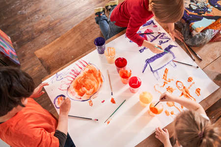 Caucasian kids drawing funny picture together with acrylic paints at the art schoolの写真素材