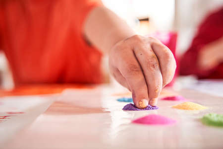 Little male child taking glitter with his hand for his pictureの写真素材