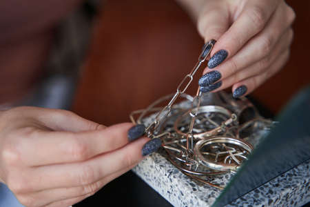 Woman examining her jewelry while sitting at home and preparing for the walking