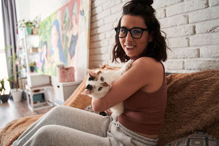 Female person holding at the hands her lovely white cat and looking with him at the cameraの写真素材