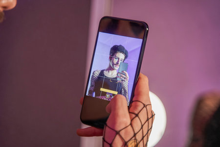 Man with mustaches shooting himself at the new creative look at his smartphone