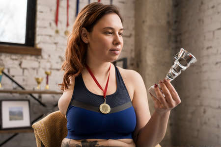 Caucasian handicap woman looking at her prize while relaxing at homeの写真素材