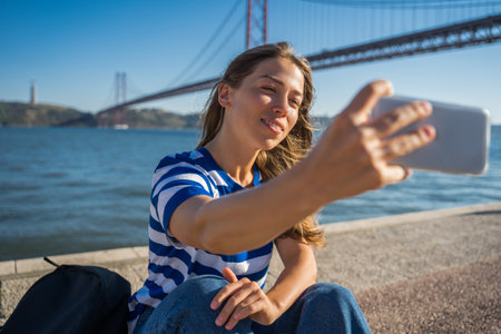 Adorable teen woman taking self portrait at her smartphoneの写真素材