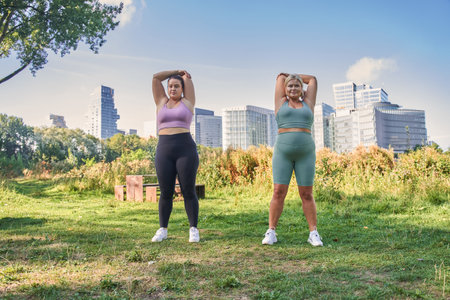 Delighted enthusiastic plus size women stretching arms whileの写真素材